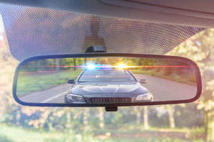 cop in rear view mirror for suspected DUI