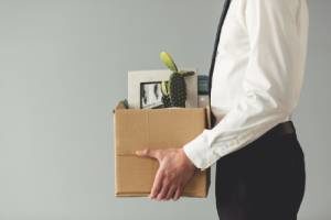 A man taking a box of his stuff home after wrongful termination