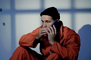 a man in jail making a call to an attorney after being accused of robbery