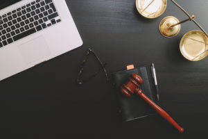 Gavel sitting on desk next to laptop