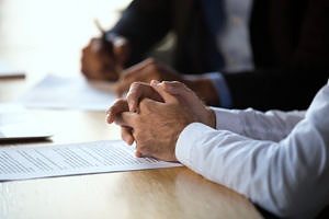 person sitting at a litigation meeting with paperwork