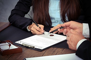 a police excessive force attorney speaking with a client and signing documents