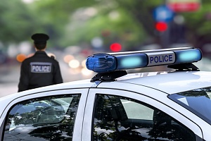 an individual sitting in a police car after falling victim to police excessive force