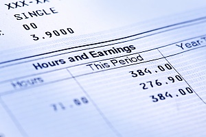 close up view of a paystub showing wages and hours and earnings on it