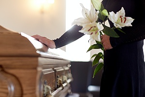 women putting flowers on grave of a wrongful death