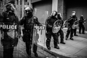 police are in riot gear and watching demonstration against police brutality