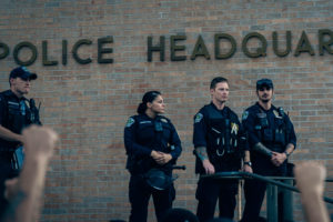 police guard their headquarters while they watch protest against police brutality