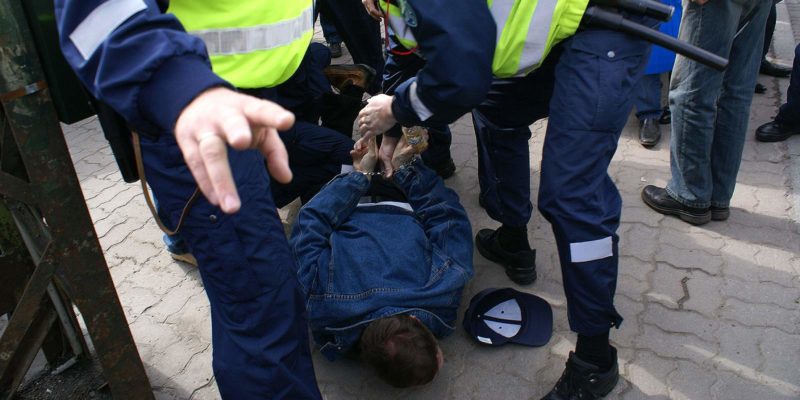 Police officer using excessive force to subdue a protestor