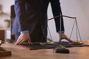 a lawyer standing up while meeting a with client who has an unlawful detainment case