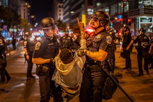 a protester is being taken by policemen