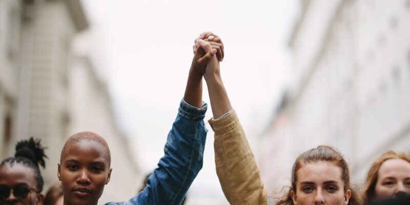 group of activists with holding hands protesting in the city