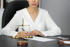 scales of justice and businesswoman sitting at table