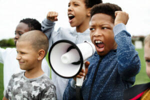 young boy shouting on a megaphone in a protest