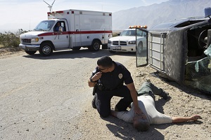 police officer checking pulse of car crash victim