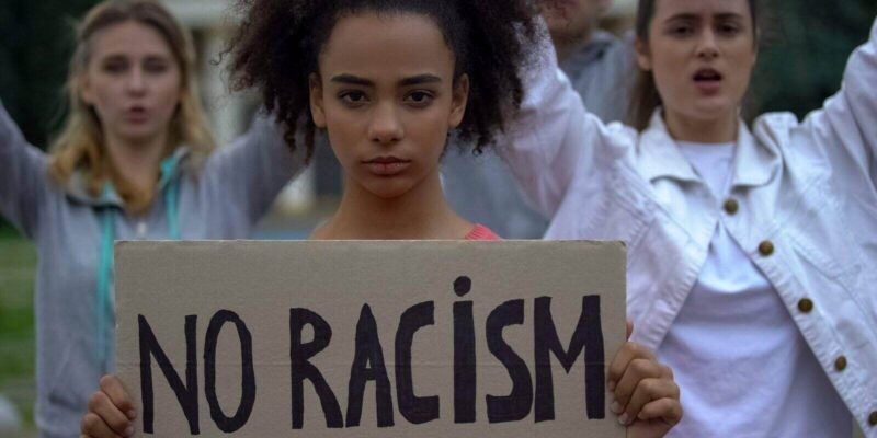 girl holding no racism sign