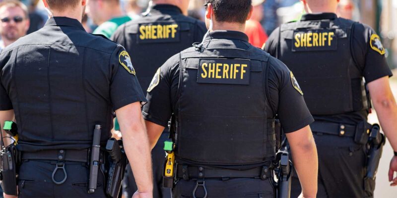 Police officers with tasers attached to their belts