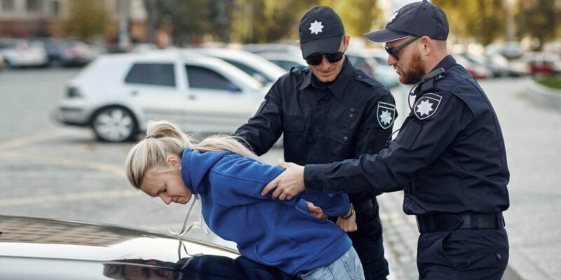 two male police officers arrest female driver