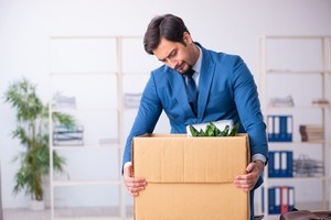 A man showing an expression of disappointment while holding a cartoon box