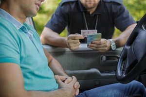 A male traffic police officer checking the license of a driver