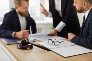 Three attorneys discussing a lawsuit