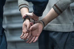 A police officer is arresting a man