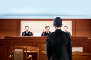 An attorney representing his case to the jury of three judges in the courtroom